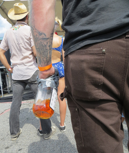 Yes, that is a bottle of Jim Beam taped to a man's hand.